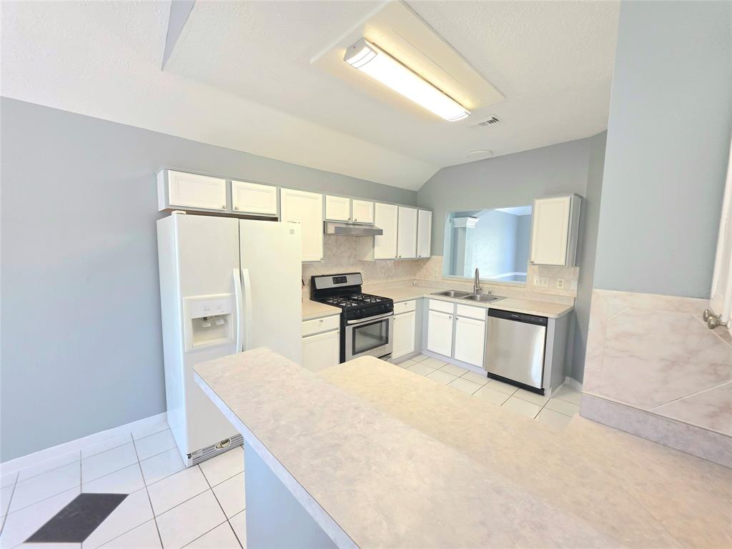 13618 Sablegrove Lane Houston, TX 77014 - Photo 7 of 30 a kitchen with granite countertop white cabinets and stainless steel appliances