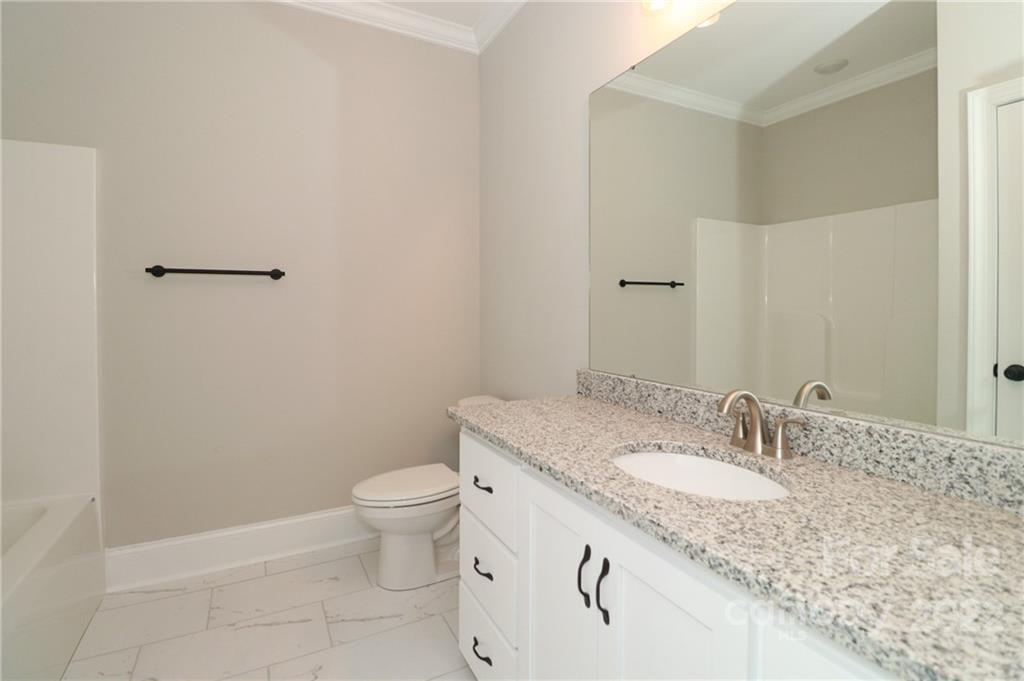 289 Ikerd Drive Southeast Concord, NC 28025 - Photo 18 of 24 a bathroom with a granite countertop sink a toilet and a mirror