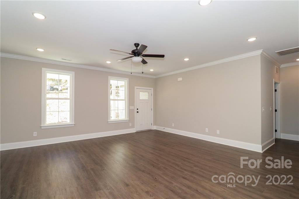 289 Ikerd Drive Southeast Concord, NC 28025 - Photo 4 of 24 a view of an empty room with a window and wooden floor