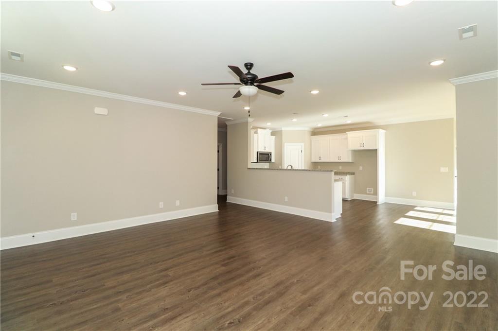 289 Ikerd Drive Southeast Concord, NC 28025 - Photo 5 of 24 a view of a kitchen an empty room and a kitchen with wooden floor