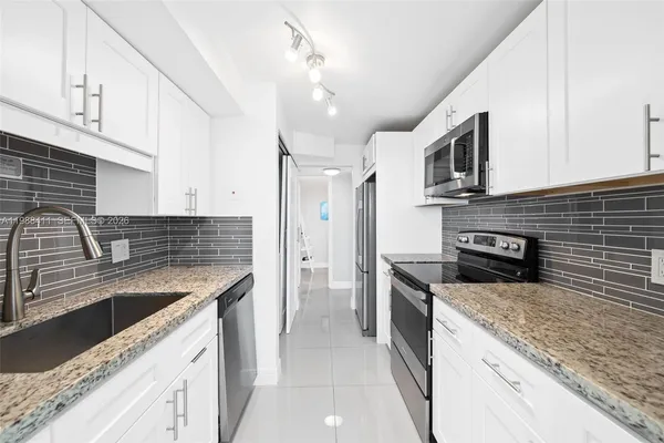 a kitchen with stainless steel appliances granite countertop a sink a stove oven and granite counter tops
