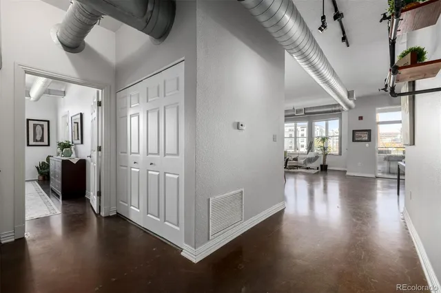 a view of a livingroom with wooden floor and a kitchen space