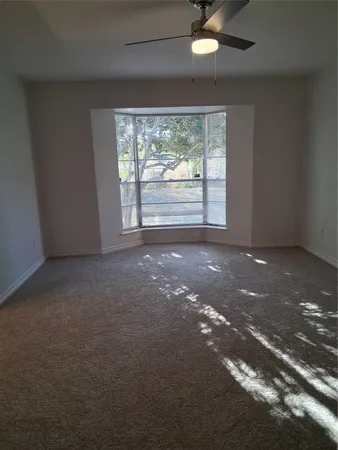 a view of a livingroom with a ceiling fan and window