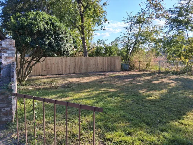 a view of a yard with wooden fence