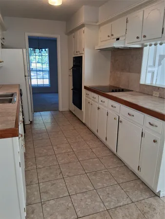 a kitchen with granite countertop white cabinets and window