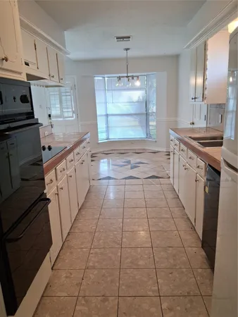 a large kitchen with granite countertop a stove a sink and dishwasher