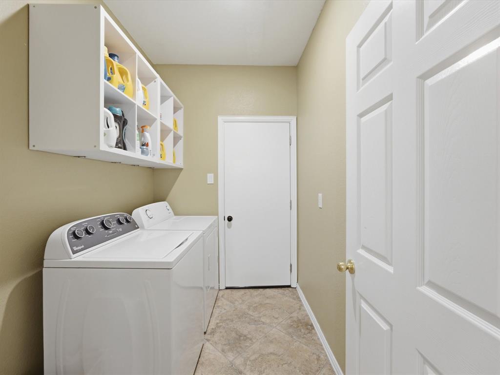 4008 Falcon Ridge Drive Haltom City, TX 76137 - Photo 33 of 40 Dedicated laundry area featuring a top-load washing machine and dryer, overhead white storage cubbies, neutral wall paint, and patterned floor tiles
