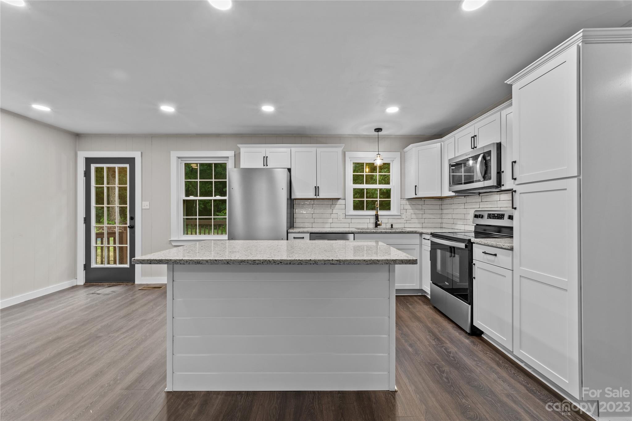 1809 Feature Road Lancaster, SC 29720 - Photo 11 of 32 a kitchen with stainless steel appliances granite countertop a refrigerator a stove top oven a sink dishwasher and white cabinets with wooden floor