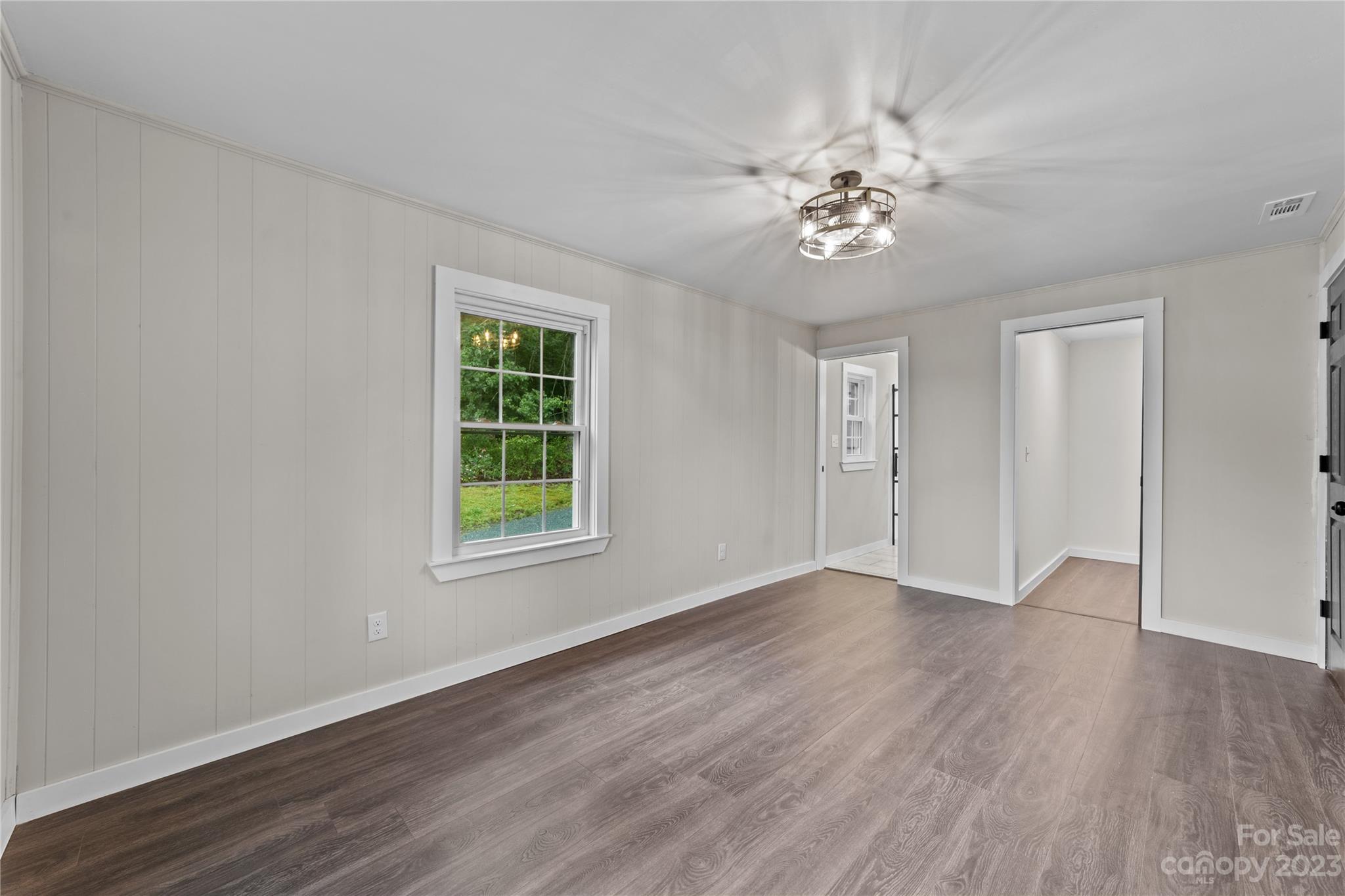1809 Feature Road Lancaster, SC 29720 - Photo 18 of 32 an empty room with wooden floor chandelier fan and windows