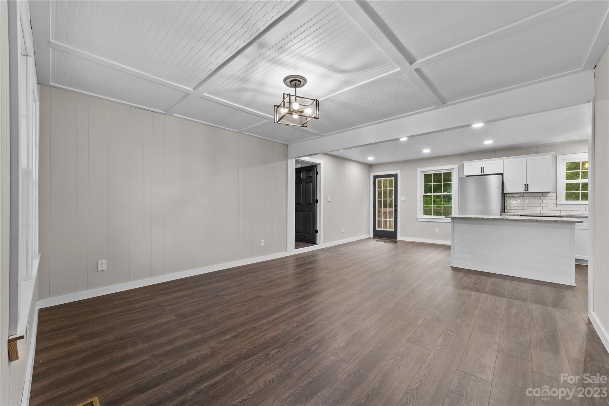 1809 Feature Road Lancaster, SC 29720 - Photo 6 of 32 a view of an empty room with wooden floor and a kitchen