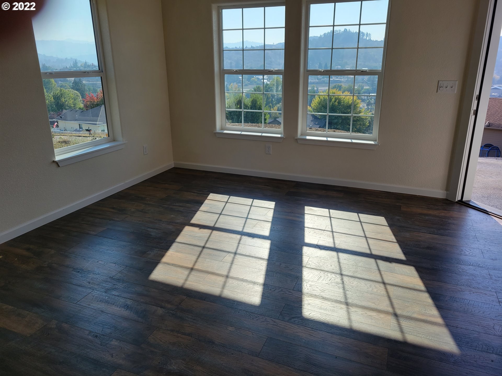 195 Armande Loop Roseburg, OR 97471 - Photo 3 of 28 an empty room with wooden floor and windows