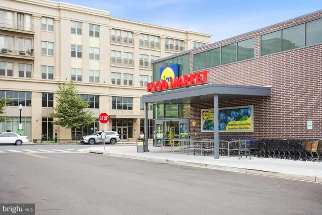 a front view of multi story building with retail shops