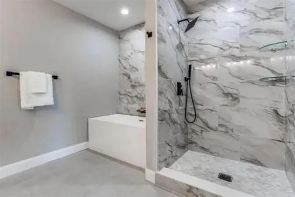 a bathroom with a toilet a sink a mirror a shower and vanity