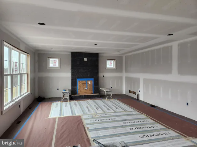 a view of an empty room with a fireplace and a window