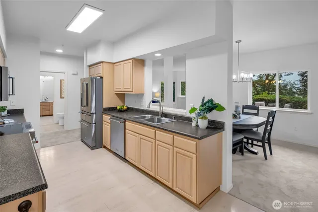 a kitchen with granite countertop a sink stove and cabinets