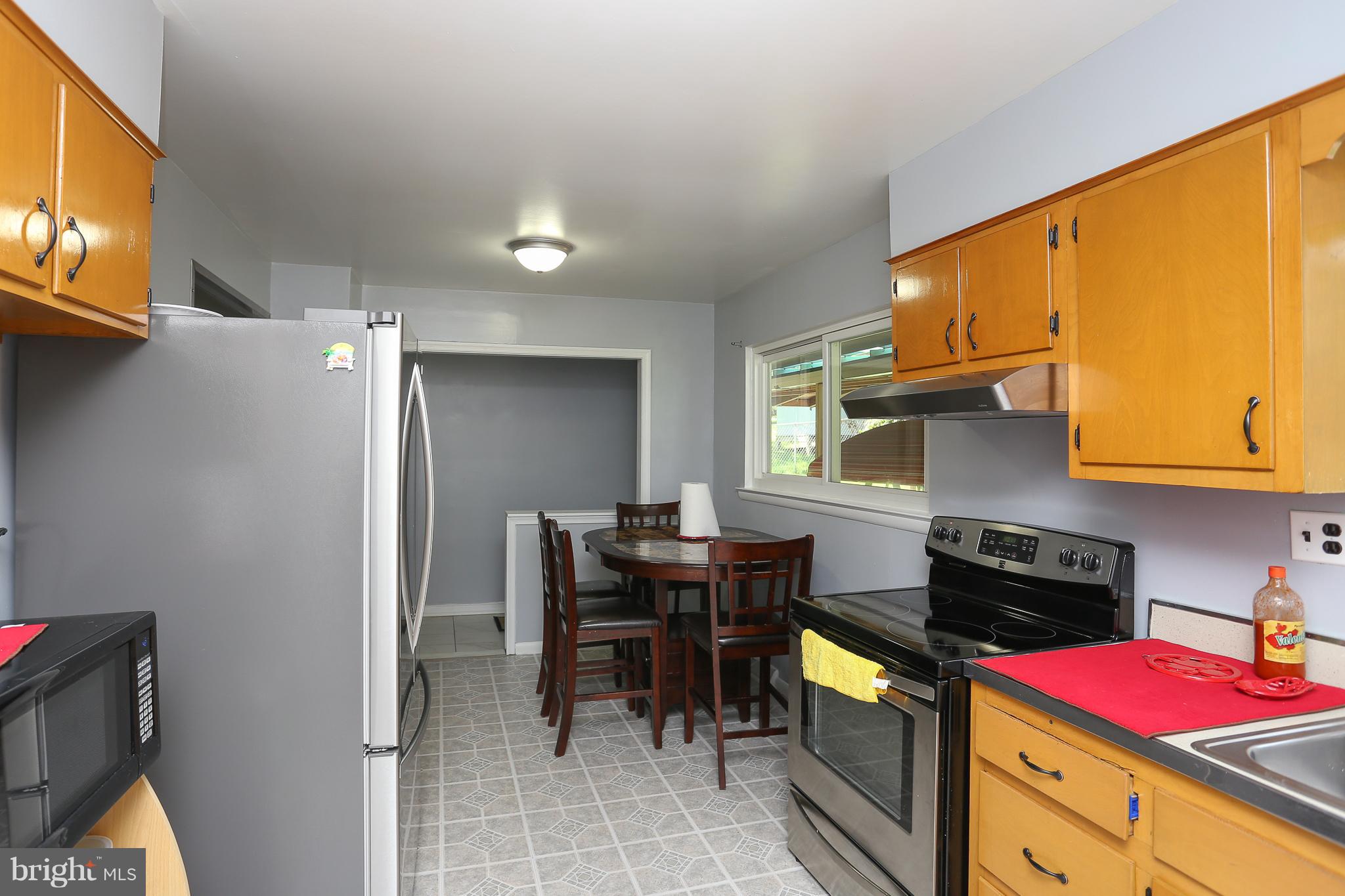 6609 Woodland Road Morningside, MD 20746 - Photo 11 of 30 a kitchen with a sink cabinets and dining table chair