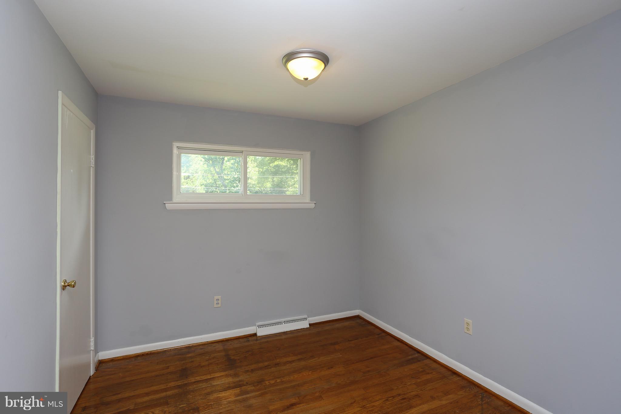 6609 Woodland Road Morningside, MD 20746 - Photo 20 of 30 a view of an empty room with wooden floor and a window