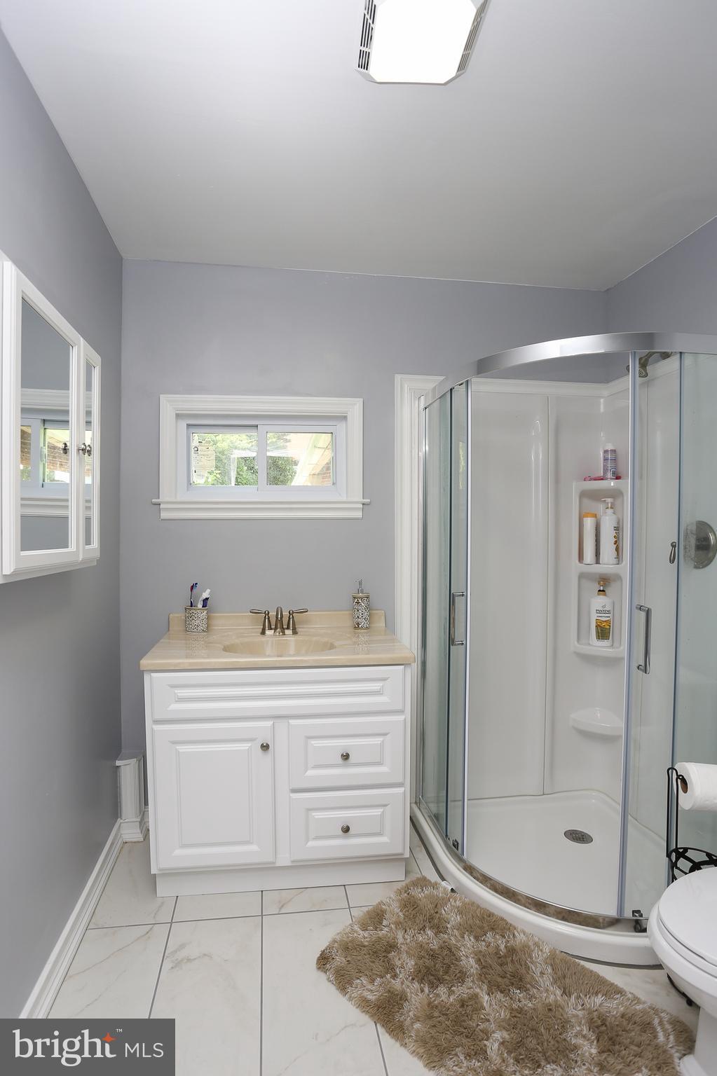 6609 Woodland Road Morningside, MD 20746 - Photo 23 of 30 a spacious bathroom with a granite countertop sink a toilet and shower