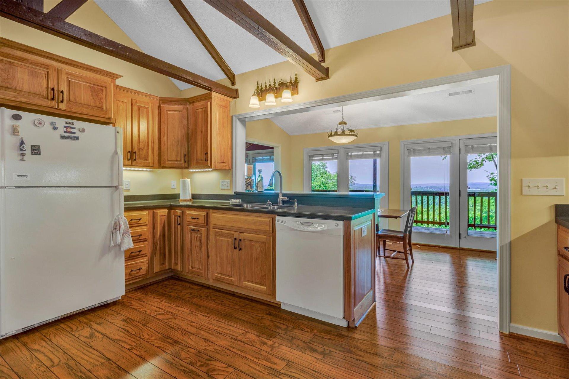 2005 Walnut Knob Road Southeast Floyd, VA 24091 - Photo 21 of 71 a kitchen with stainless steel appliances granite countertop a refrigerator a sink dishwasher a stove and a dining table with wooden floor