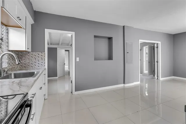 a kitchen with white cabinets stainless steel appliances and a refrigerator