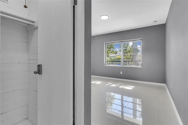 a view of an empty room with window and bathroom