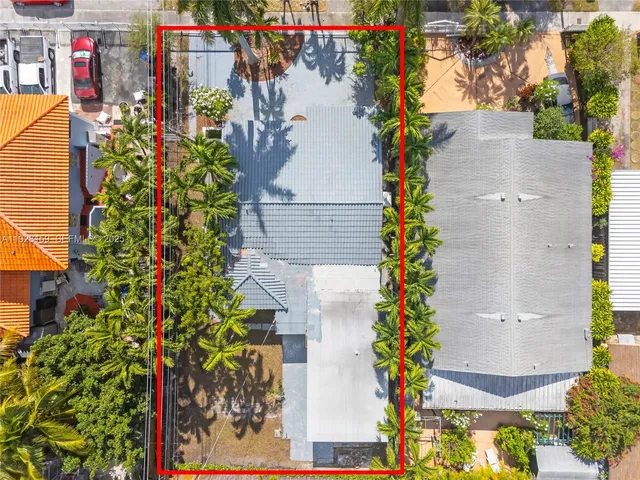 an aerial view of residential houses with outdoor space and trees
