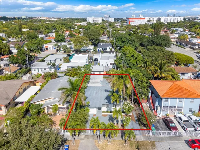 an aerial view of residential houses with outdoor space and trees