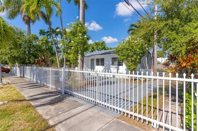 a view of a house with a small yard and wooden fence