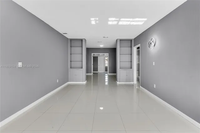 wooden floor in an empty room with a kitchen