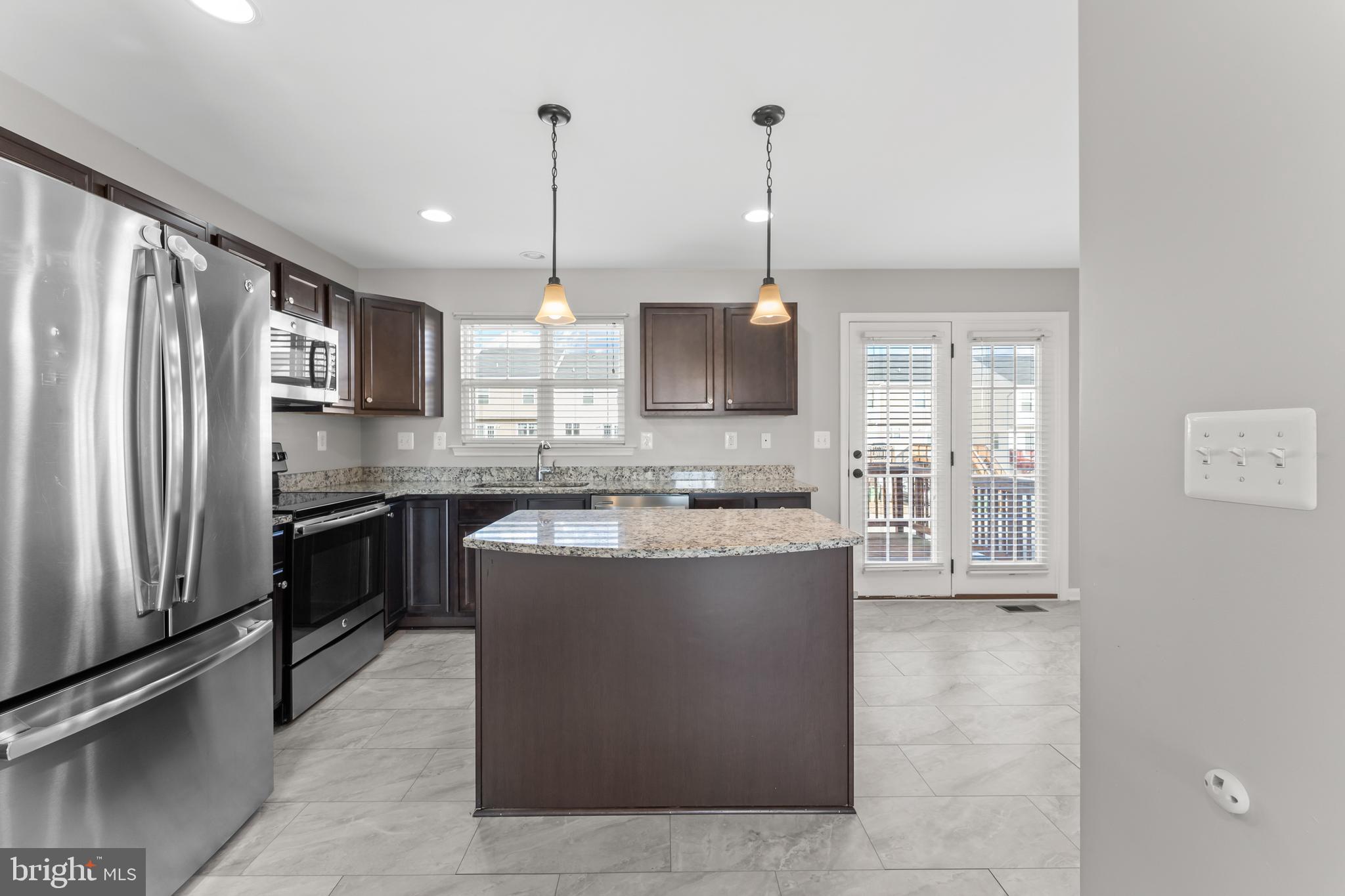 18315 Congressional Circle Ruther Glen, VA 22546 - Photo 15 of 37 a large kitchen with kitchen island a counter top a stove a sink and a refrigerator