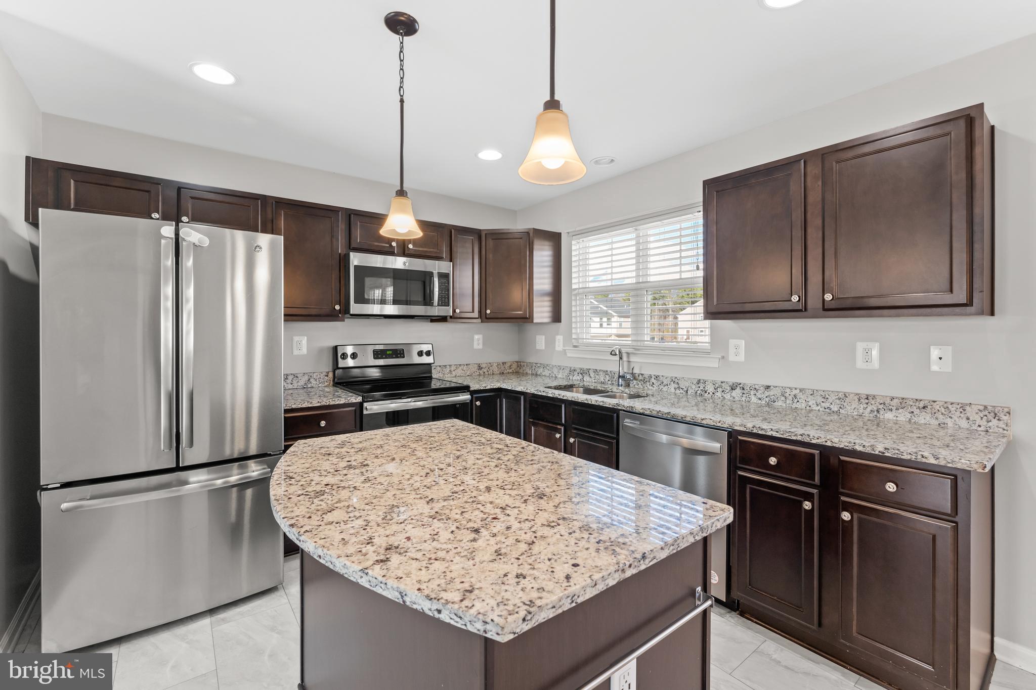 18315 Congressional Circle Ruther Glen, VA 22546 - Photo 19 of 37 a kitchen with stainless steel appliances granite countertop a refrigerator a sink a stove a microwave and island