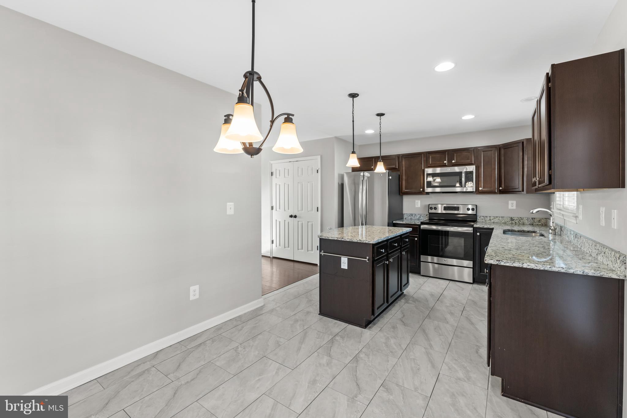 18315 Congressional Circle Ruther Glen, VA 22546 - Photo 20 of 37 a large kitchen with stainless steel appliances kitchen island granite countertop a stove a sink a refrigerator and a microwave