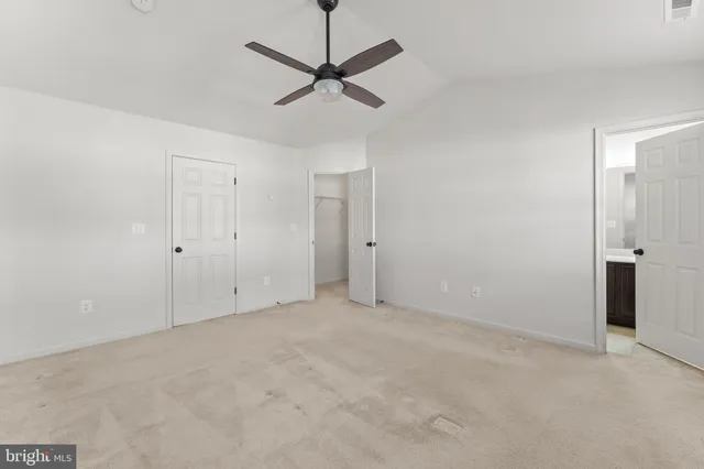 an empty room with a ceiling fan and a window
