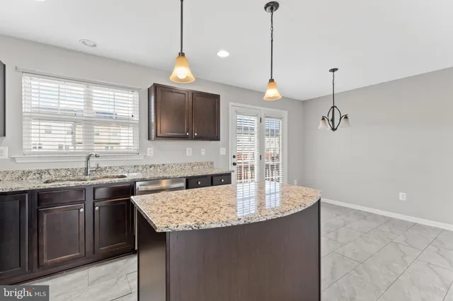 a kitchen with a sink a center island and cabinets