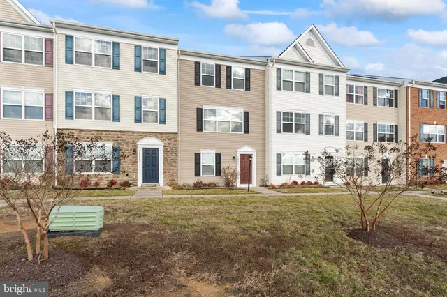 a front view of a residential apartment building with a yard