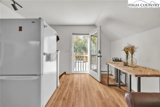 a view of kitchen with stainless steel appliances granite countertop a refrigerator and a stove top oven