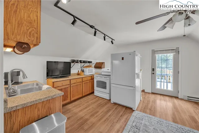 a kitchen with a refrigerator cabinets and wooden floor