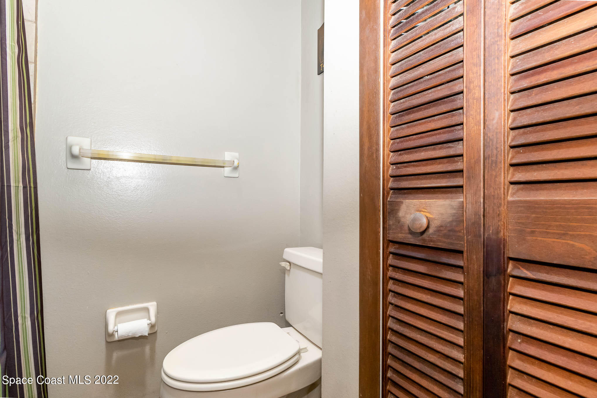 2539 Fulton Court Melbourne, FL 32935 - Photo 11 of 19 a white toilet sitting next to a shower curtain