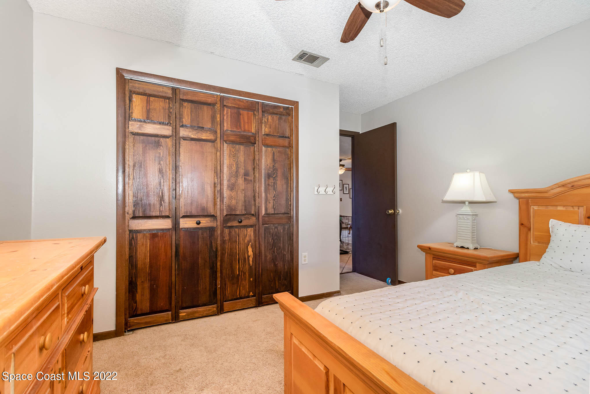 2539 Fulton Court Melbourne, FL 32935 - Photo 14 of 19 a bedroom with a bed and a chandelier