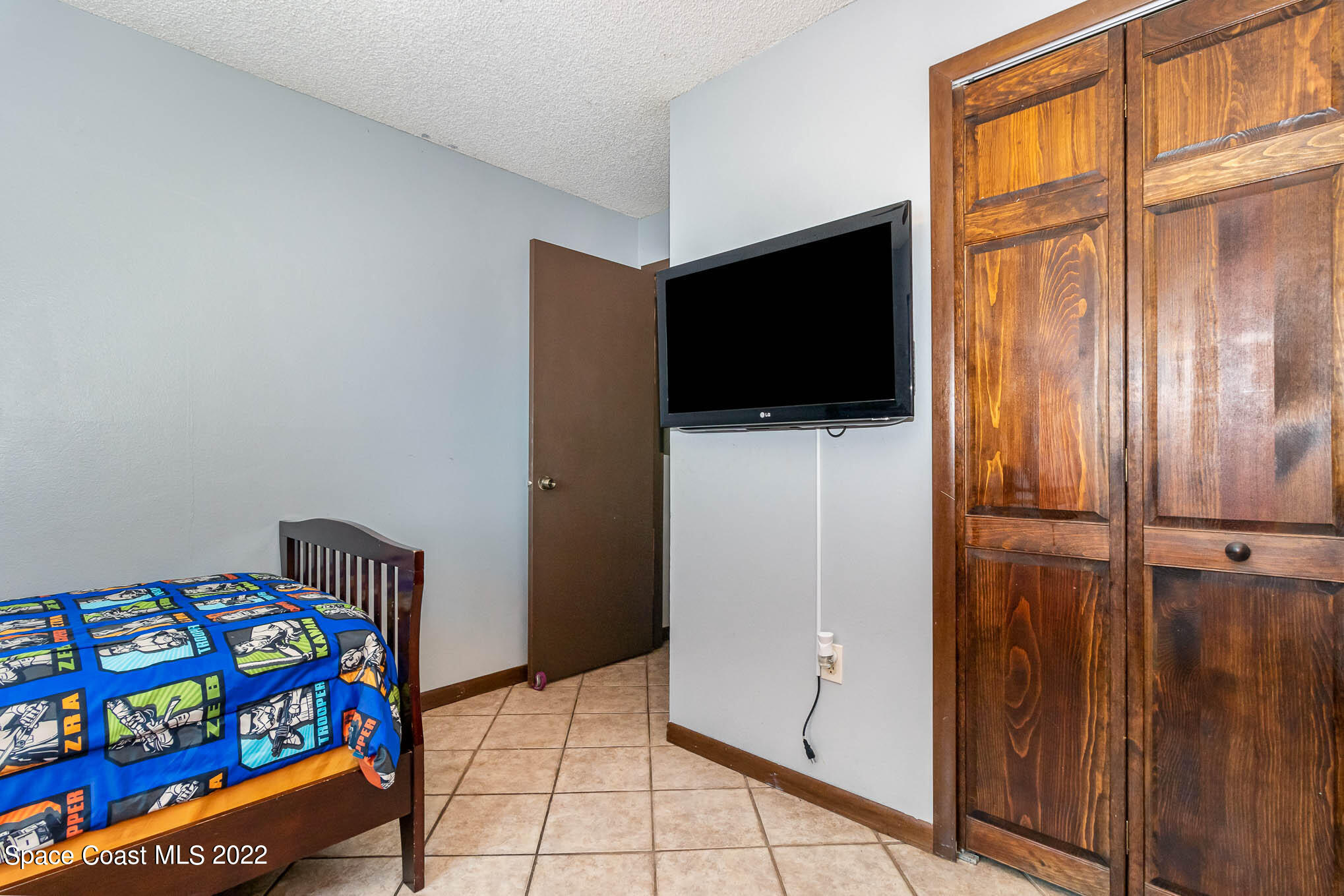 2539 Fulton Court Melbourne, FL 32935 - Photo 17 of 19 a hallway with painting on the wall and a flat screen tv