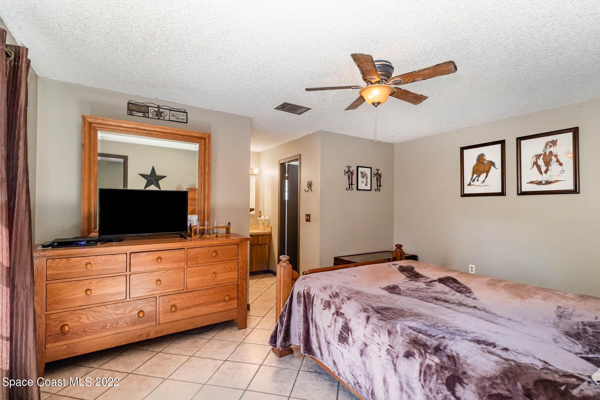 2539 Fulton Court Melbourne, FL 32935 - Photo 9 of 19 a bedroom with a bed and a mirror on dresser