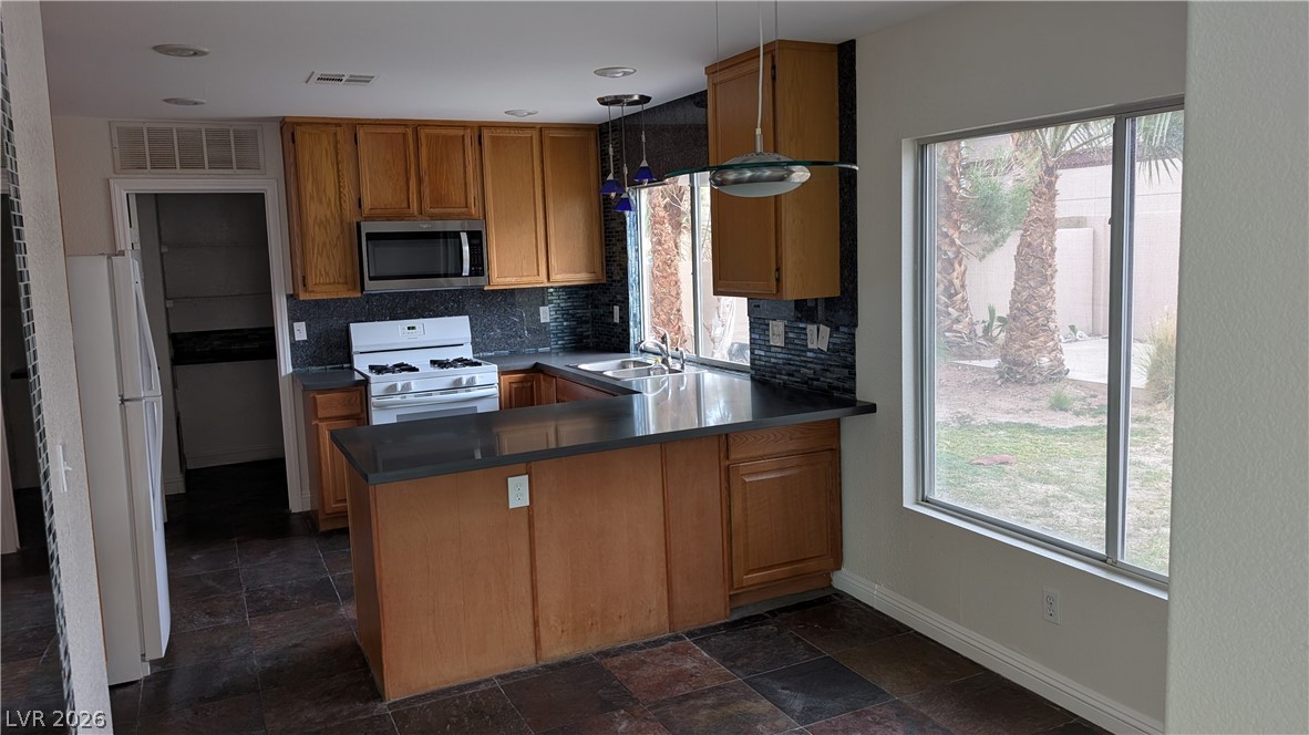 2670 Ridgewater Circle Henderson, NV 89074 - Photo 6 of 22 This functional kitchen features a breakfast bar, ample cabinetry, and direct backyard views.