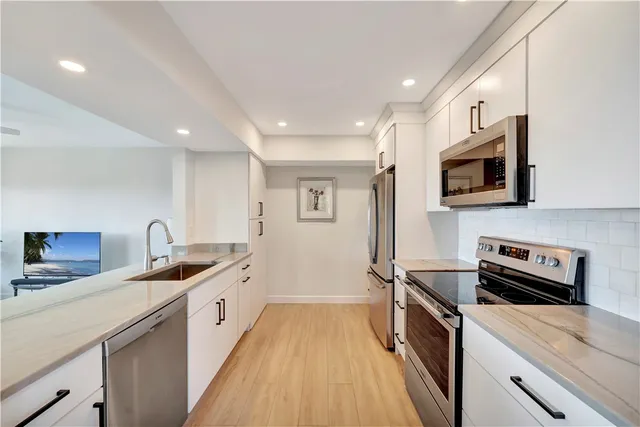 a kitchen with stainless steel appliances a sink a stove and a microwave