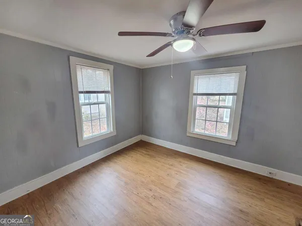 a view of empty room with wooden floor