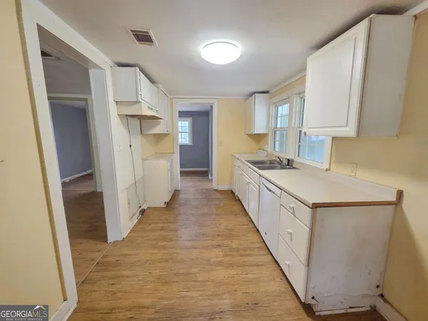 a kitchen with white cabinets and sink