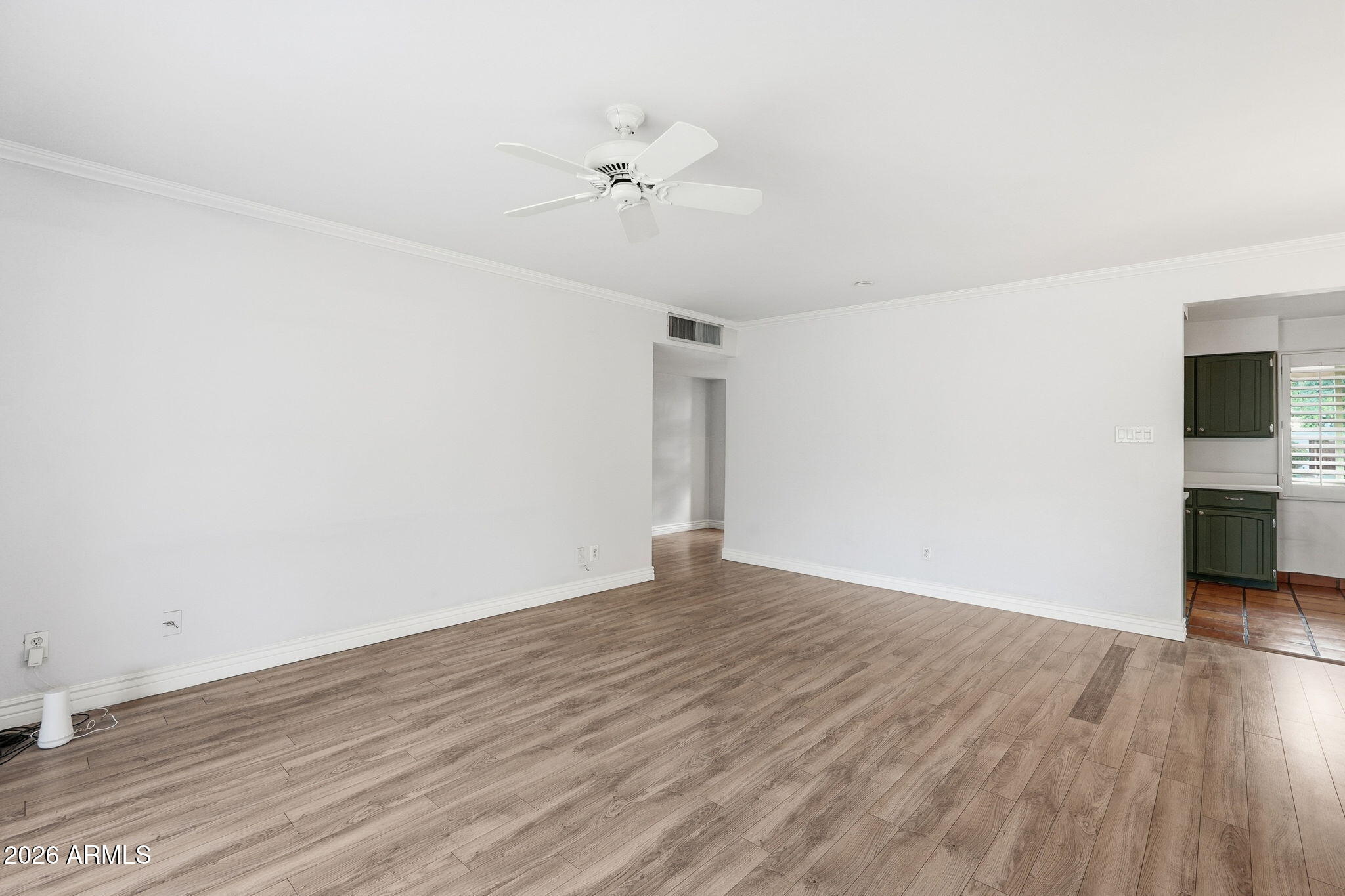 4702 North 30th Place Phoenix, AZ 85016 - Photo 16 of 34 a view of an empty room with wooden floor and a ceiling fan