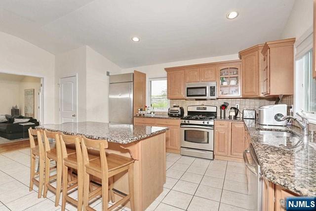 84 12th Street Cresskill, NJ 07626 - Photo 23 of 45 a kitchen with stainless steel appliances granite countertop a stove top oven a sink a dining table and chairs
