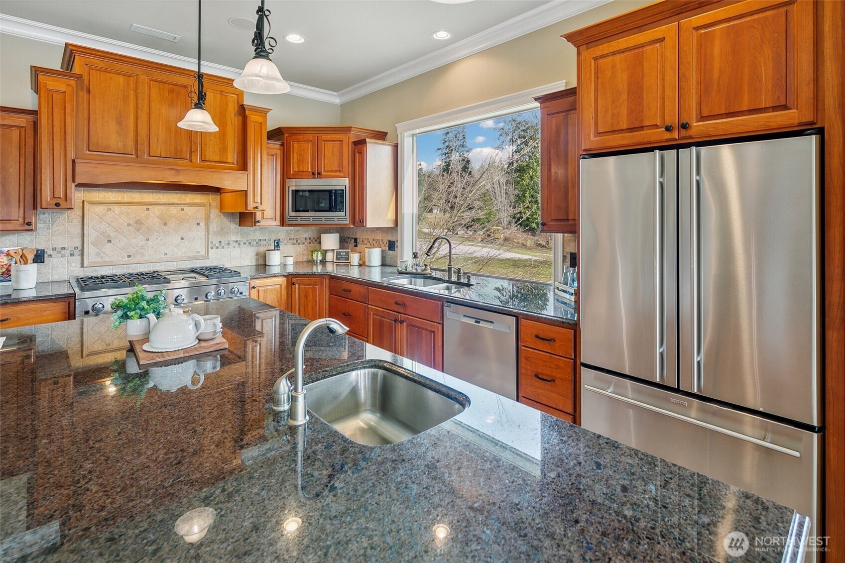 3505 Newberg Road Snohomish, WA 98290 - Photo 9 of 40 a kitchen with stainless steel appliances granite countertop wooden cabinets a sink a stove a dining table and chairs