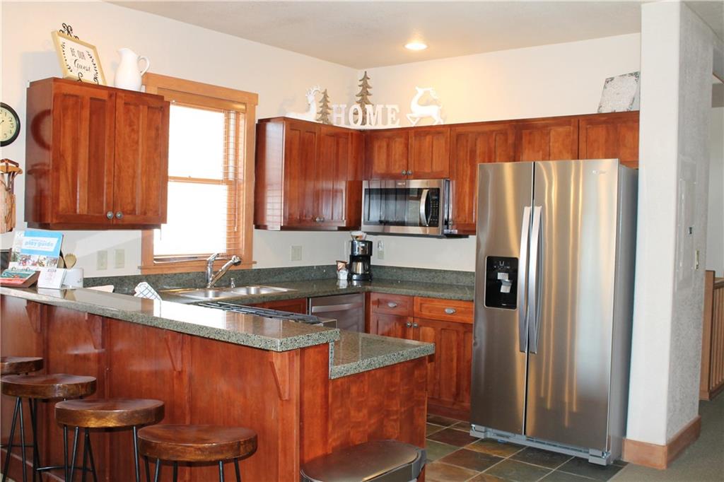 161 Hawk Circle, Unit 2336 Keystone, CO 80435 - Photo 4 of 29 a kitchen with stainless steel appliances granite countertop a refrigerator a sink a stove a microwave and island