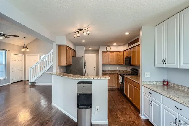 a kitchen with stainless steel appliances kitchen island granite countertop a stove and a sink